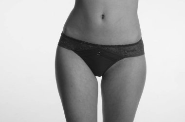 Beyaz arka planda yalnız poz veren dantelli iç çamaşırlı güzel kadın. 