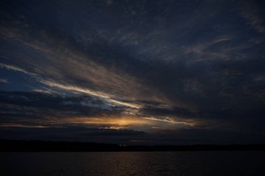 Sabahın erken saatlerinde gölün üzerinde sonsuz karanlık gökyüzü manzarası.   