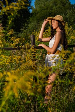 Yeşil çayırlarda poz veren yaz kıyafetleri içinde güzel bir kadın. 