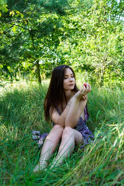 Donkerharige vrouw poseert bij de houten pier bij het meer. Vrouw in zomerkleding met haar rug naar de houten voetgangersbrug van het Neusiedlmeer. Zon reflecties bij het boothuis op de achtergrond. — Stockfoto