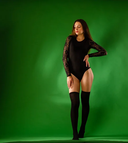 Girl in black bodysuit on green background — Stock Photo, Image