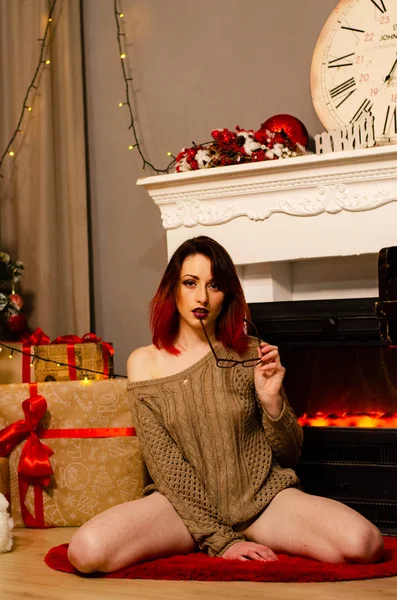 Una niña hermosa sosteniendo una copa de champán y una botella de ella en una sesión de fotos de Año Nuevo en el estudio. El concepto de Año Nuevo . — Foto de Stock