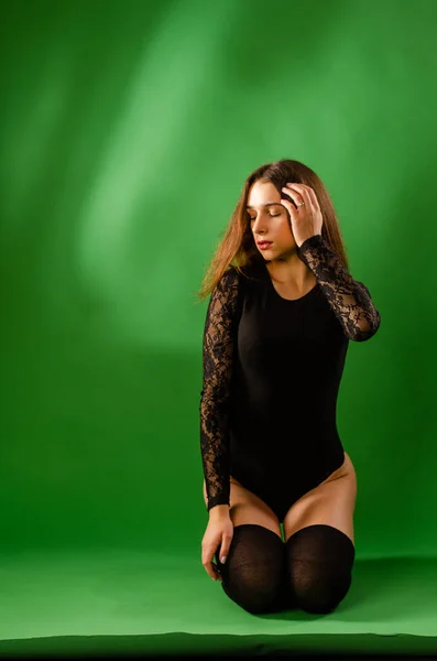 Menina em preto bodysuit no fundo verde — Fotografia de Stock