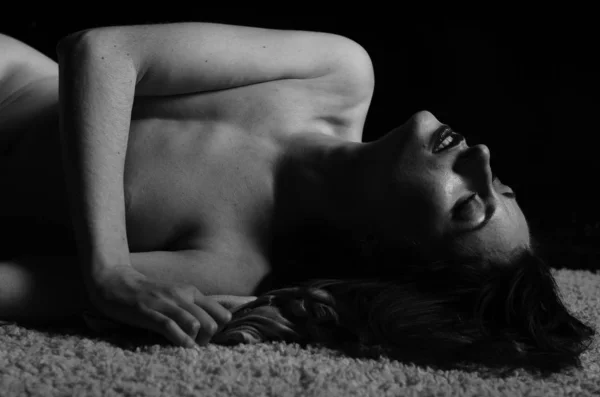 美丽的裸体女人躺在黑暗的房间里 — 图库照片