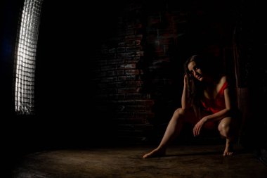 Güzel esmer kadın kırmızı arka planda kırmızı iç çamaşırlarıyla poz veriyor. Stüdyoda kırmızı elbiseli esmer kadın. Formda bir kız. Güzellik, moda ve tarz kavramı. Sevgililer Günü.