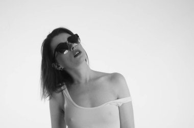 Beyaz tişörtlü güzel kadın beyaz arka planda yalnız poz veriyor. 