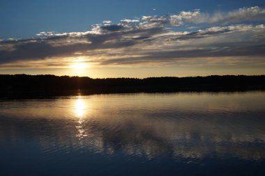 Gün batımının resimsel görüntüsü gölün ayna yüzeyine yansıyor 
