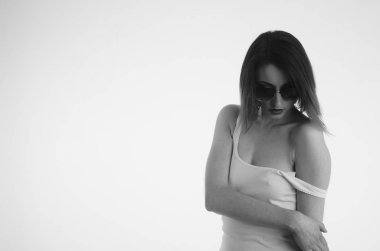 Beyaz tişörtlü güzel kadın beyaz arka planda yalnız poz veriyor. 