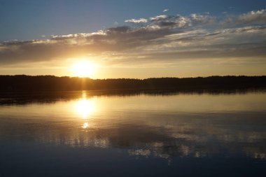 Gün batımının resimsel görüntüsü gölün ayna yüzeyine yansıyor 
