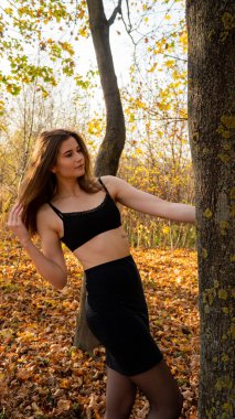 Sonbaharda parkta yürüyen genç ve güzel bir kadın.