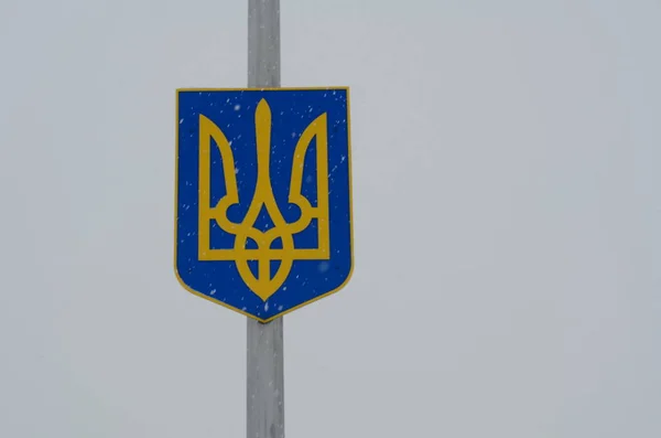 pole with coat of arms of Ukraine sign on sky background