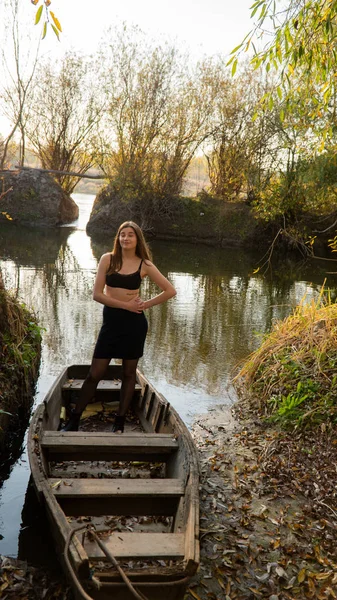 木製ボートの上の秋の公園の美しい少女 — ストック写真