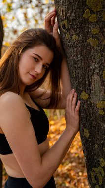 Sonbaharda parkta yürüyen genç ve güzel bir kadın.