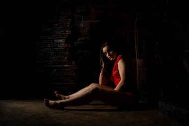 Güzel esmer kadın kırmızı arka planda kırmızı iç çamaşırlarıyla poz veriyor. Stüdyoda kırmızı elbiseli esmer kadın. Formda bir kız. Güzellik, moda ve tarz kavramı. Sevgililer Günü.