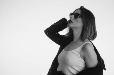 Beyaz tişörtlü güzel kadın beyaz arka planda yalnız poz veriyor. 