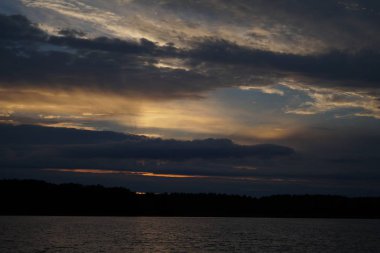 Sabahın erken saatlerinde gölün üzerinde sonsuz karanlık gökyüzü manzarası.   
