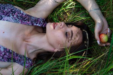 Gölün oradaki tahta iskelede poz veren siyah saçlı kadın. Sırtı Neusiedl Gölü 'nün tahta yaya köprüsüne dönmüş bir kadın. Arka plandaki kayıkhanede güneş yansımaları.