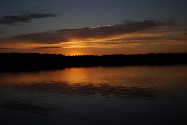 Sabahın erken saatlerinde gölün üzerinde sonsuz karanlık gökyüzü manzarası.   