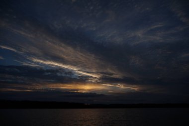 Sabahın erken saatlerinde gölün üzerinde sonsuz karanlık gökyüzü manzarası.   