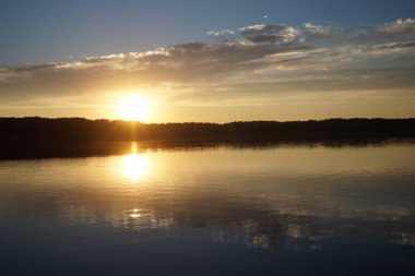 Gün batımının resimsel görüntüsü gölün ayna yüzeyine yansıyor 