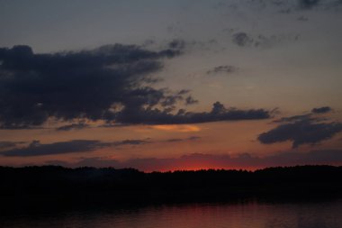 Sabahın erken saatlerinde gölün üzerinde sonsuz karanlık gökyüzü manzarası.   