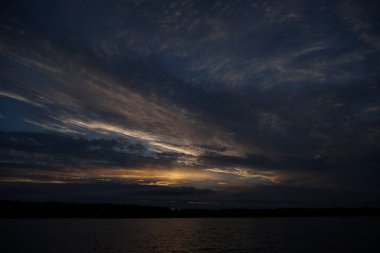 Sabahın erken saatlerinde gölün üzerinde sonsuz karanlık gökyüzü manzarası.   