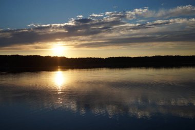 Gün batımının resimsel görüntüsü gölün ayna yüzeyine yansıyor 