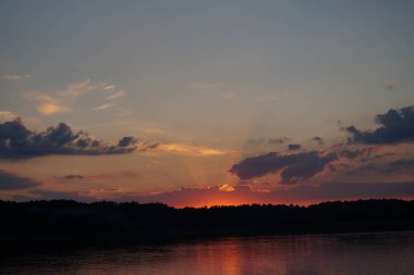 Gün batımının resimsel görüntüsü gölün ayna yüzeyine yansıyor 