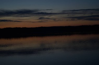 Sabahın erken saatlerinde gölün üzerinde sonsuz karanlık gökyüzü manzarası.   
