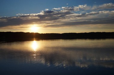 Gün batımının resimsel görüntüsü gölün ayna yüzeyine yansıyor 