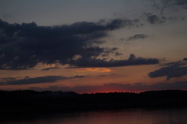 Sabahın erken saatlerinde gölün üzerinde sonsuz karanlık gökyüzü manzarası.   