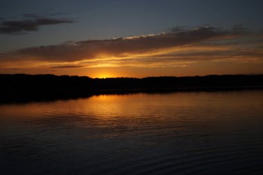 Sabahın erken saatlerinde gölün üzerinde sonsuz karanlık gökyüzü manzarası.   