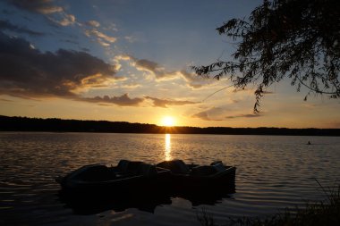 Günbatımı göl manzarasında gün batımı gemisi