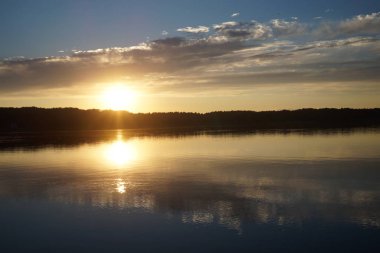 Gün batımının resimsel görüntüsü gölün ayna yüzeyine yansıyor 