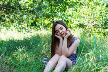 Gölün oradaki tahta iskelede poz veren siyah saçlı kadın. Sırtı Neusiedl Gölü 'nün tahta yaya köprüsüne dönmüş bir kadın. Arka plandaki kayıkhanede güneş yansımaları.