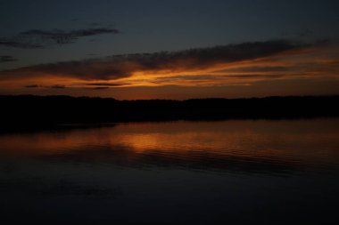 Sabahın erken saatlerinde gölün üzerinde sonsuz karanlık gökyüzü manzarası.   