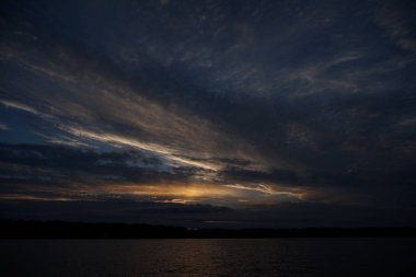 Sabahın erken saatlerinde gölün üzerinde sonsuz karanlık gökyüzü manzarası.   