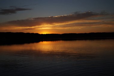 Sabahın erken saatlerinde gölün üzerinde sonsuz karanlık gökyüzü manzarası.   