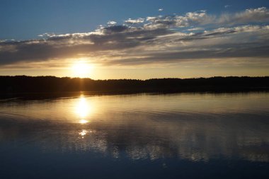 Gün batımının resimsel görüntüsü gölün ayna yüzeyine yansıyor 