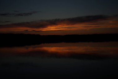 Sabahın erken saatlerinde gölün üzerinde sonsuz karanlık gökyüzü manzarası.   