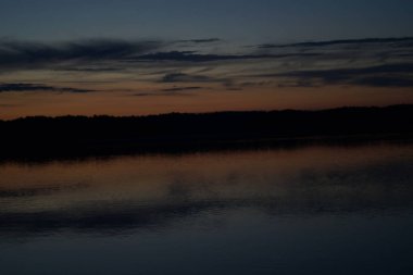 Sabahın erken saatlerinde gölün üzerinde sonsuz karanlık gökyüzü manzarası.   