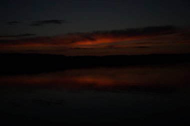 Sabahın erken saatlerinde gölün üzerinde sonsuz karanlık gökyüzü manzarası.   