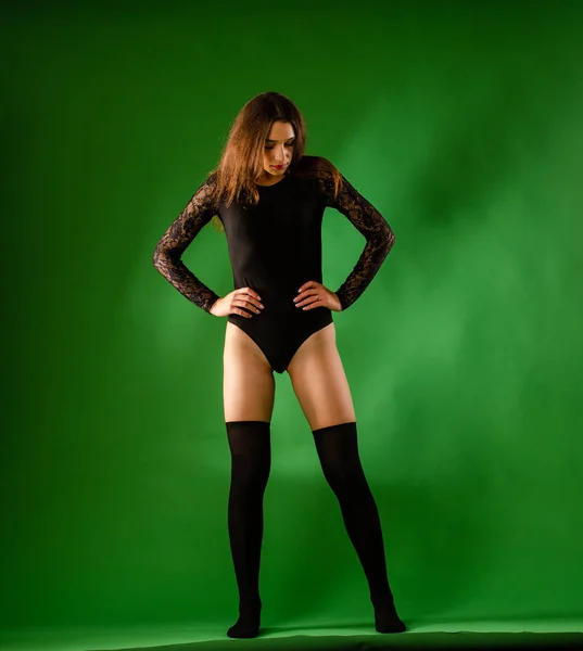 Meisje in zwart bodysuit op groene achtergrond — Stockfoto