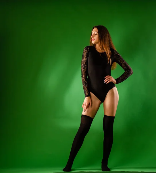 Girl in black bodysuit on green background — Stock Photo, Image