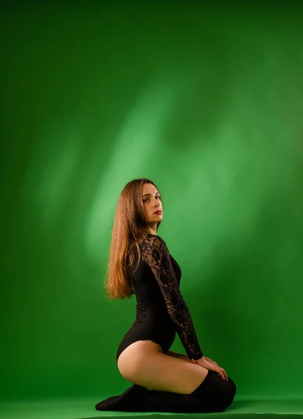 Girl in black bodysuit on green background — Stock Photo, Image