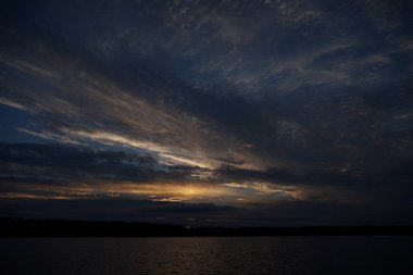 Sabahın erken saatlerinde gölün üzerinde sonsuz karanlık gökyüzü manzarası.   