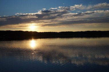 Gün batımının resimsel görüntüsü gölün ayna yüzeyine yansıyor 