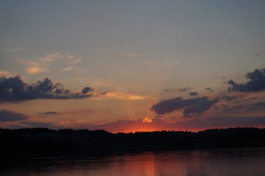 Gün batımının resimsel görüntüsü gölün ayna yüzeyine yansıyor 