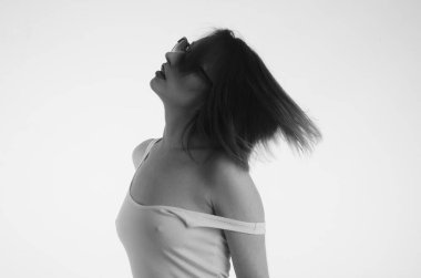 Beyaz tişörtlü güzel kadın beyaz arka planda yalnız poz veriyor. 