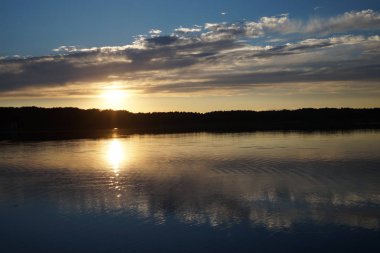 Gün batımının resimsel görüntüsü gölün ayna yüzeyine yansıyor 